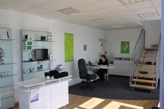 Modernes Hörakustik-Fachgeschäft mit Hörgeräten, Beratungstheke und freundlicher Beratung.